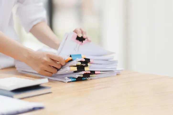 인사 담당자가 책상 위에 놓인 인사 서류철을 정리하는 모습