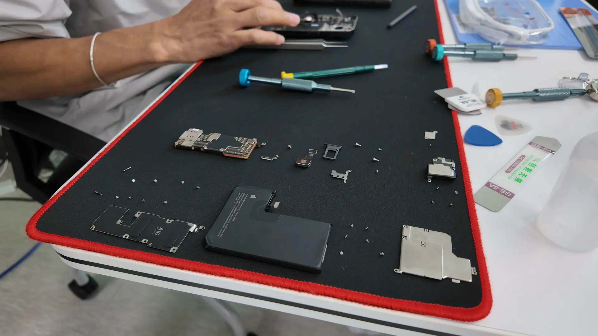 분해된 스마트폰 부품과 수리 도구를 놓고 폰수리 기술 실습을 진행하는 작업 테이블 모습