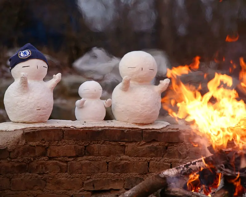Winter Fireplace zone of Nami island, Right side, there is warm fire with bright orange-red color, on the left side there are three small cute looking snowman 