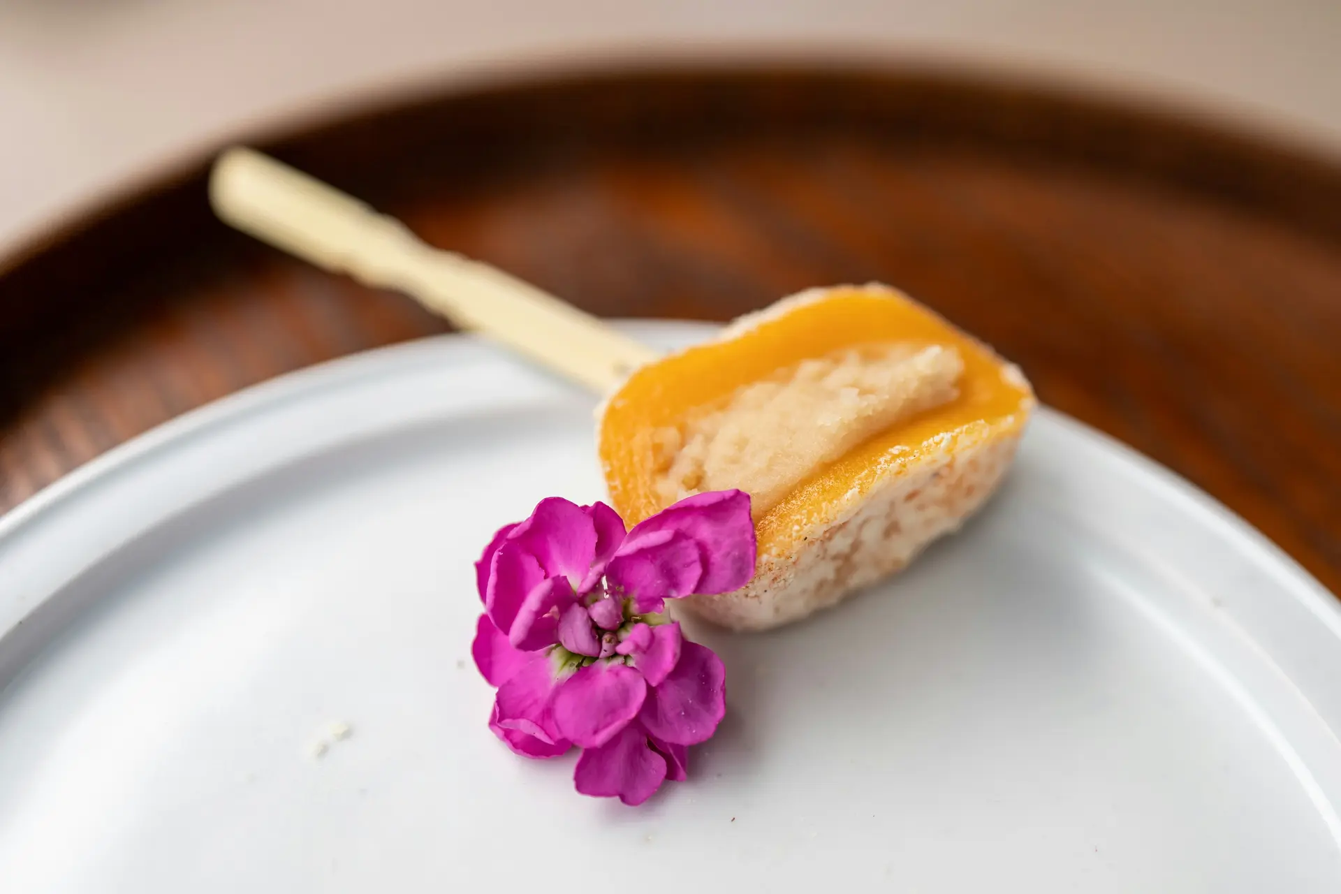 접시에 담긴 한식 디저트 형태의 떡과 장식된 꽃