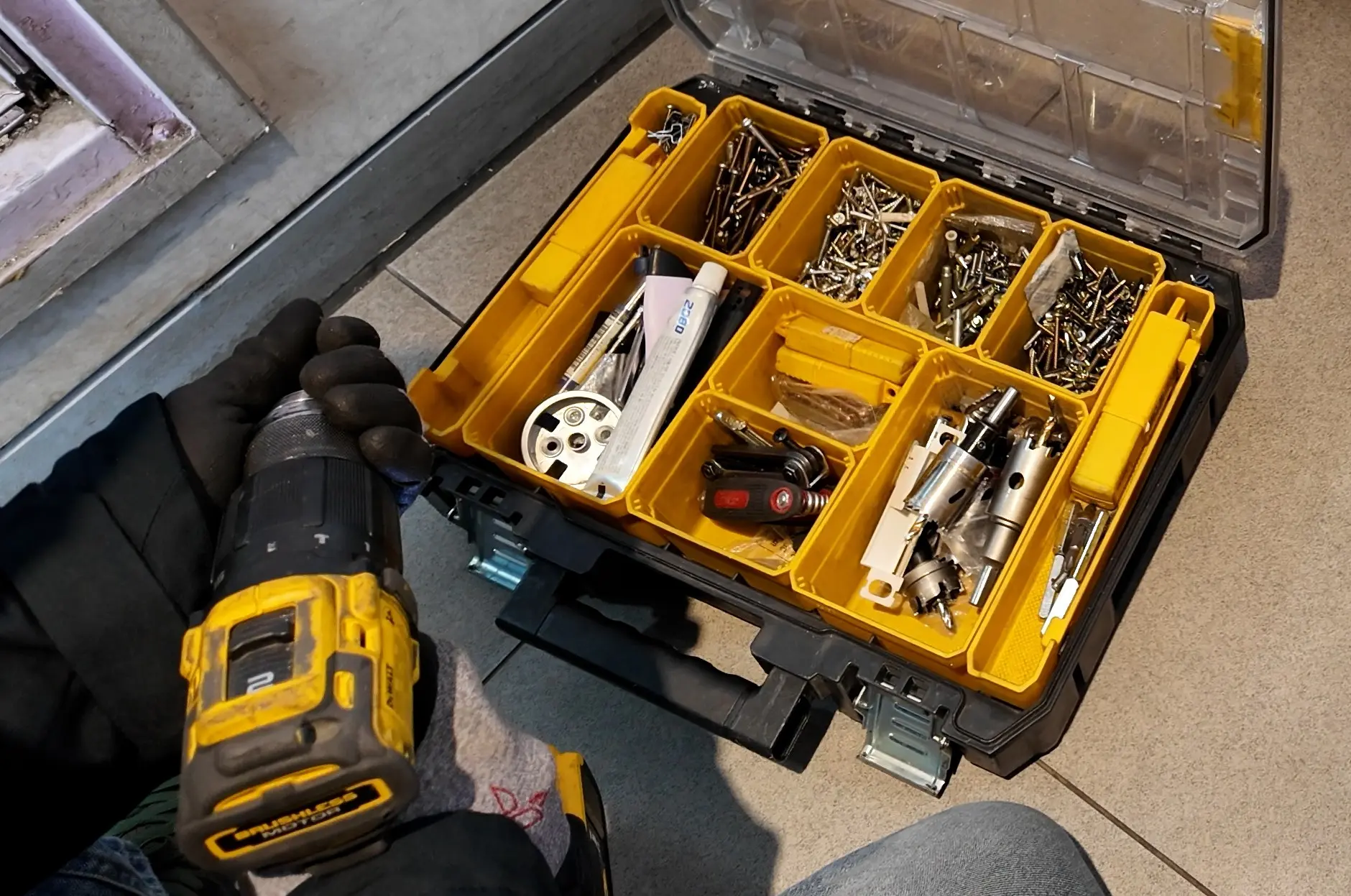 도어락 설치 작업에 사용되는 공구와 부품이 정리된 공구함