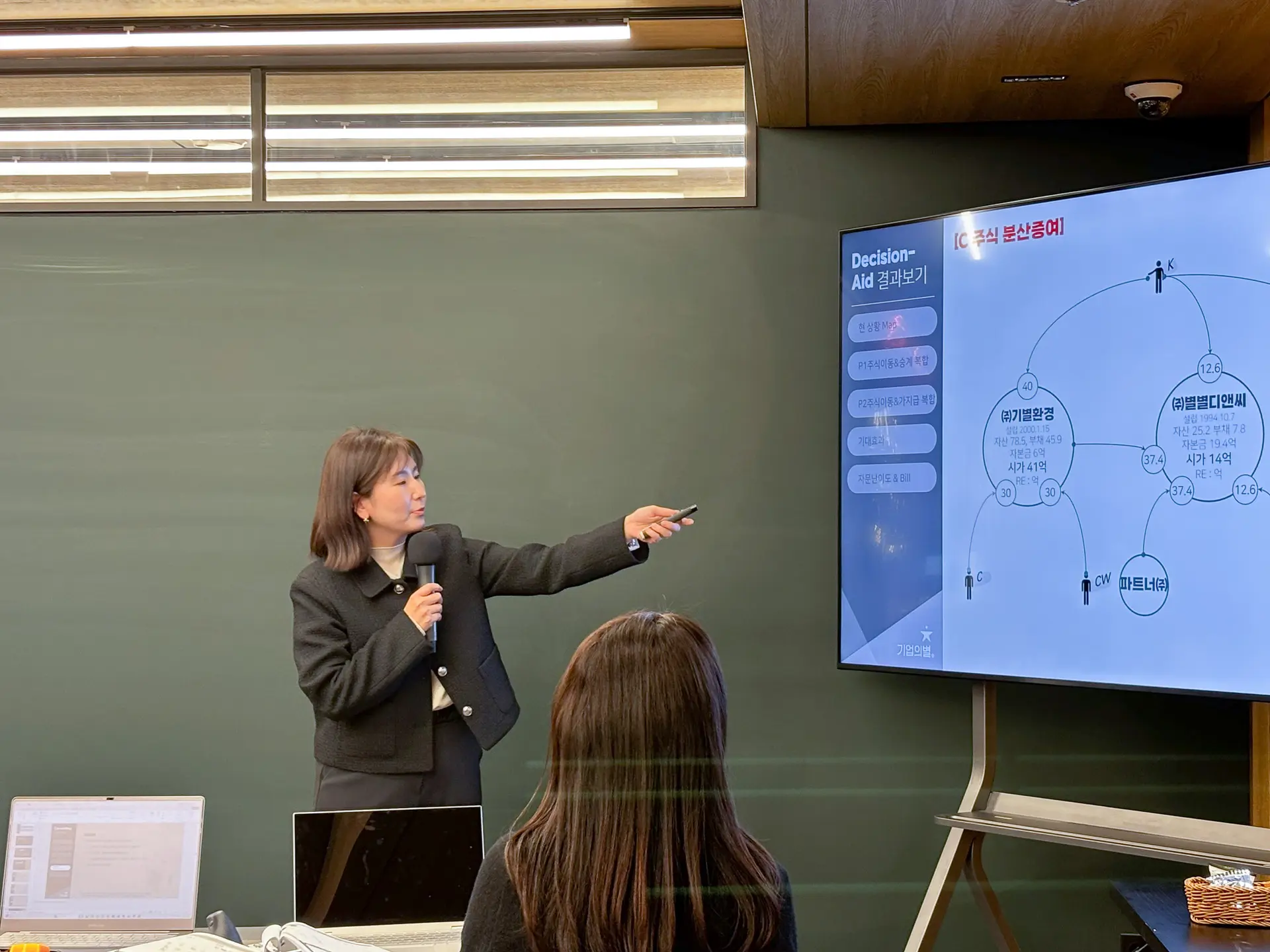김민경 위원님의 발표사진2. 포인터로 모니터를 가리키며 사례를 설명하고있다.