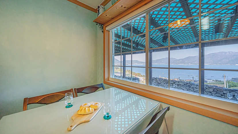 Dining table by a large window with an ocean view (Listing ID : 5203)