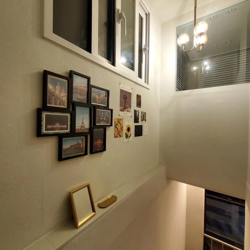 Stairwell landing with a travel-photo gallery wall and a brass chandelier (Listing ID : 6307)