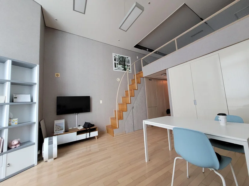 Double-height loft living area with staircase and dining table (Listing ID : 3984)
