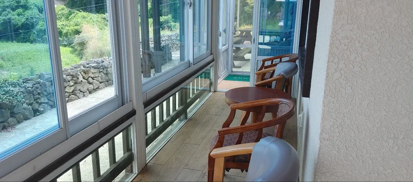 Enclosed veranda with wicker seating over the garden (Listing ID : 5203)