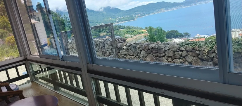 Sea and mountains over the stone wall, seen from the glassed-in porch (Listing ID : 5203)