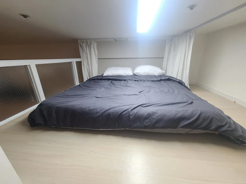 Sleeping loft with a double bed and a frosted-glass safety railing (Listing ID : 16580)