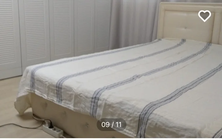 Bedroom with a tufted headboard and striped linen (Listing ID : 11420)