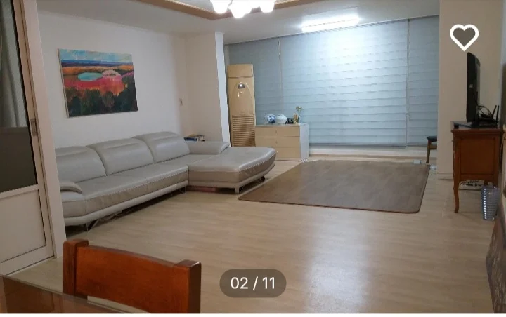 Bright living room with a grey sectional and abstract art (Listing ID : 11420)