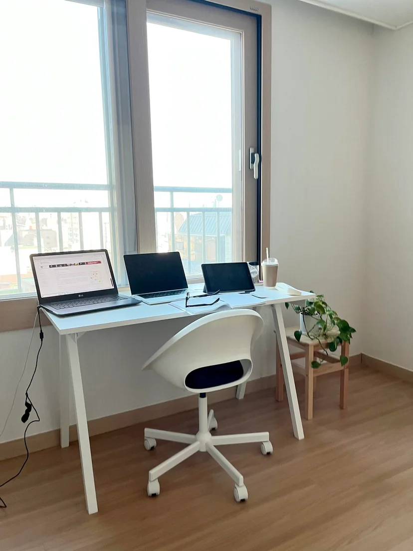 Desk by the window with laptops and a white office chair (Listing ID : 11764)