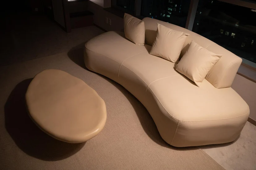 Curved cream sofa and rounded ottoman in the living area (Listing ID : 11396)