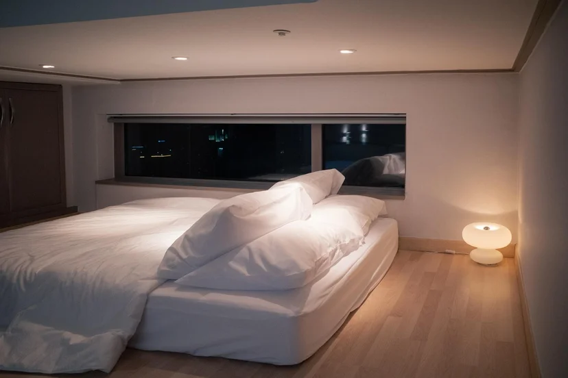 Upper loft bedroom with a low platform bed and warm lamp (Listing ID : 11396)