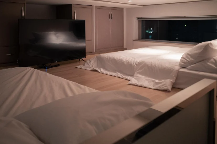 Loft sleeping area with platform beds and a city-view window (Listing ID : 11396)