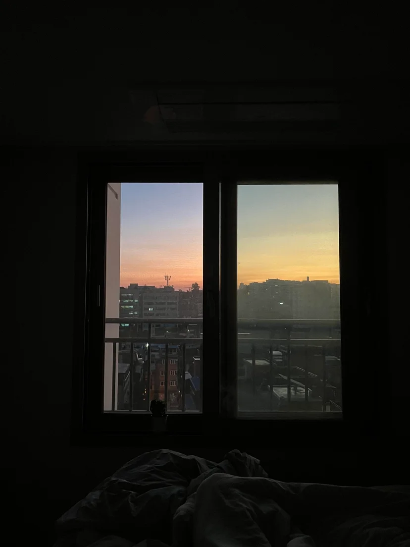 Bedroom at dusk with a window overlooking the city skyline (Listing ID : 11764)
