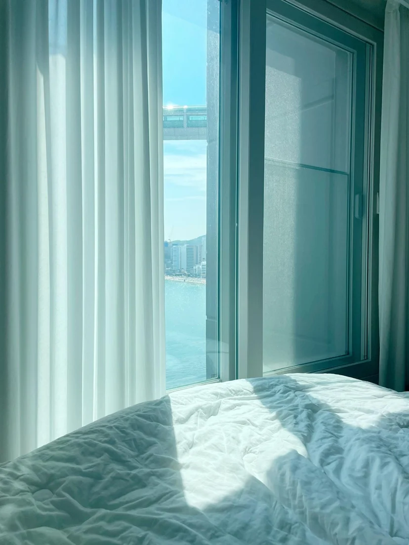 Bed beside floor-to-ceiling windows with a bridge and bay view (Listing ID : 11389)