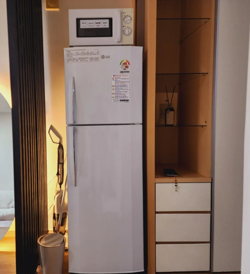 LG refrigerator with microwave next to a glass-shelf cabinet and drawer storage (Listing ID : 14800)