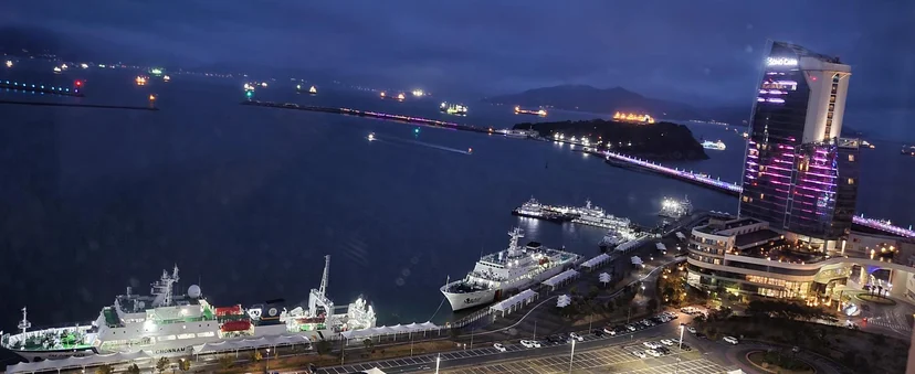 Night view over the harbour with docked boats and a lit tower (Listing ID : 21611)