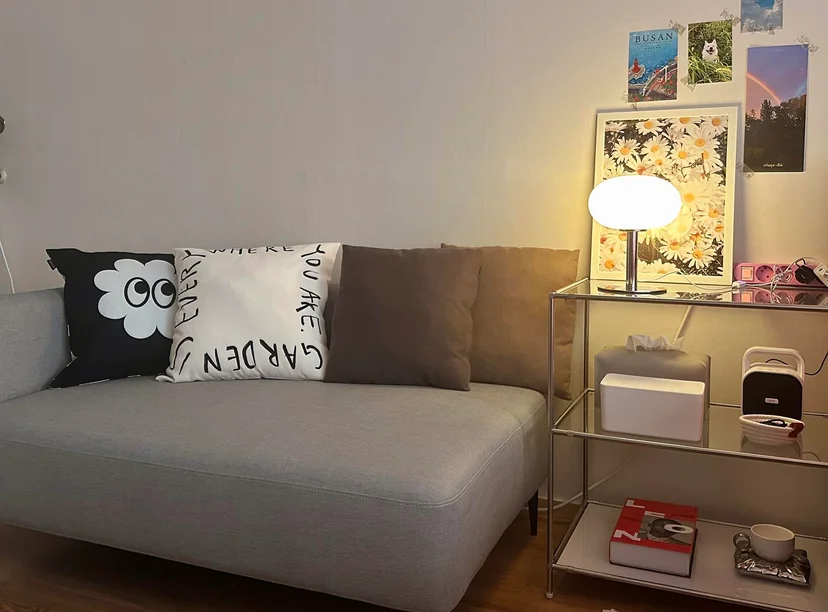 Cozy living area with gray sofa, decorative pillows, and a warm mushroom lamp on a side shelf (Listing ID : 14800)