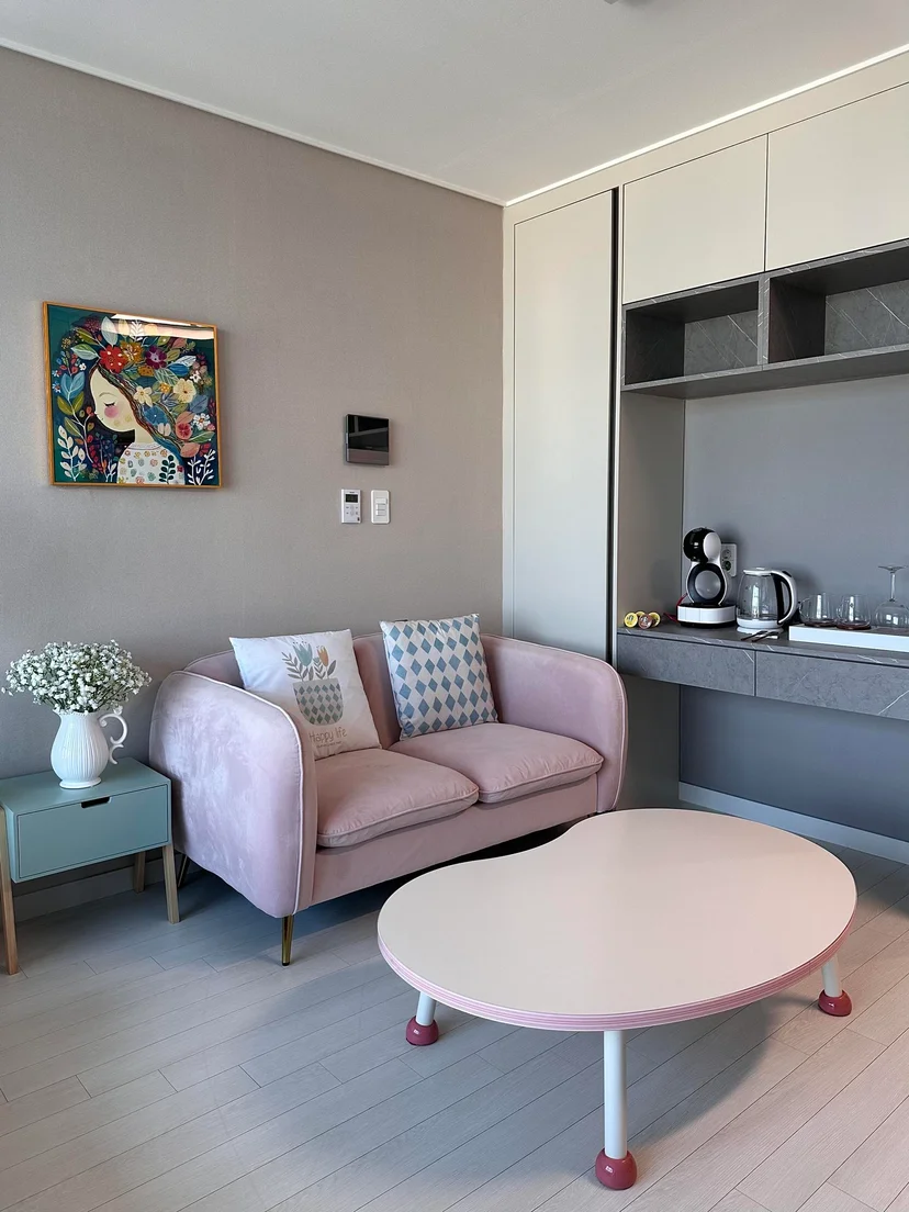 Living area with a pink sofa, kidney-shaped coffee table and a built-in coffee corner (Listing ID : 22344)