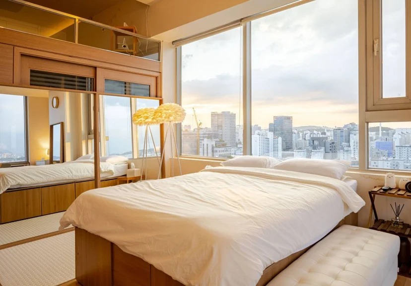 Double bed by floor-to-ceiling windows with a sunset city view (Listing ID : 33770)