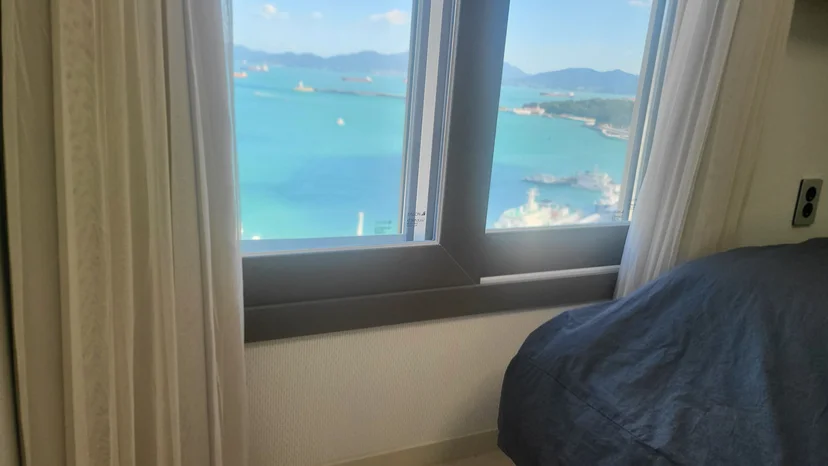 Bed beside a window overlooking the harbour and islands (Listing ID : 21611)