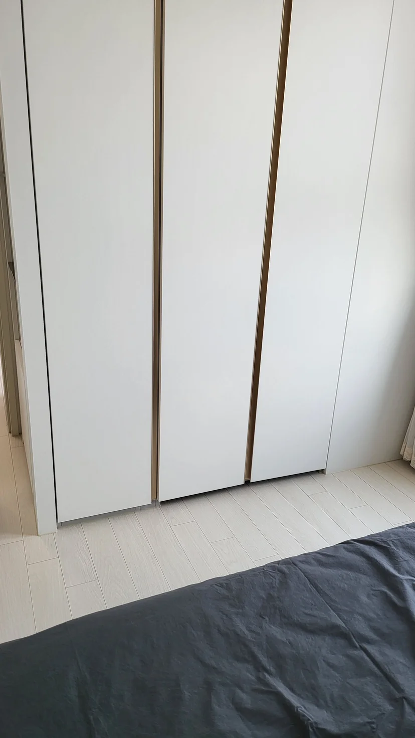 White built-in wardrobe doors beside a bed with dark grey bedding (Listing ID : 21611)