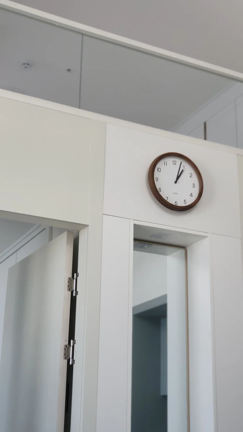 Built-in white cabinetry with a wall clock and a round mirror (Listing ID : 21611)