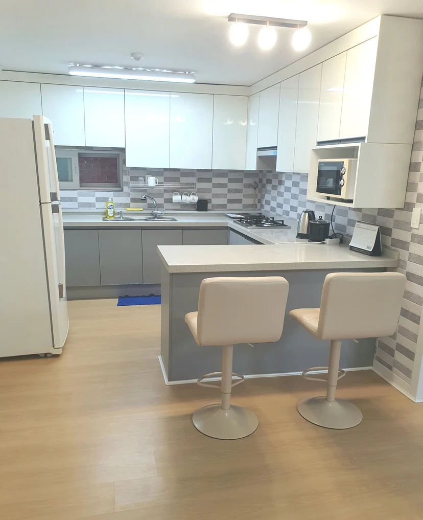 Bright kitchen with bar stools, refrigerator, and microwave (Listing ID : 43566)