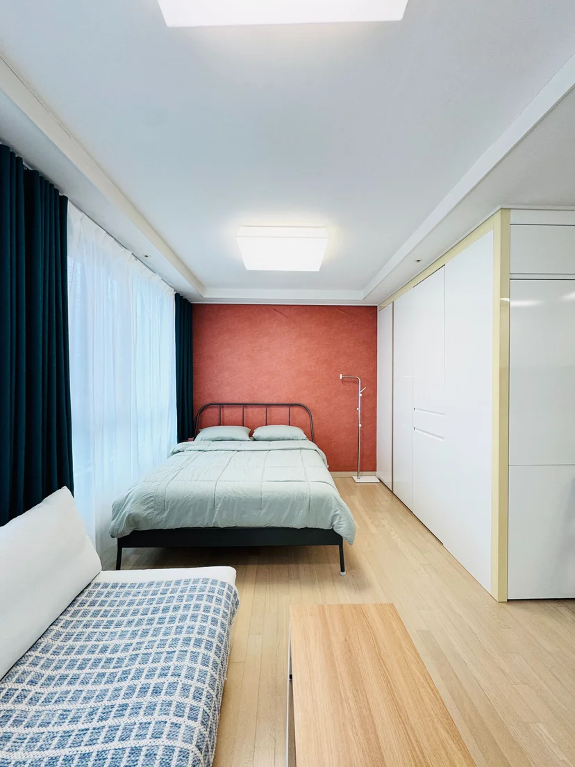 Iron-frame bed against a terracotta wall beside a tall wardrobe (Listing ID : 39296)
