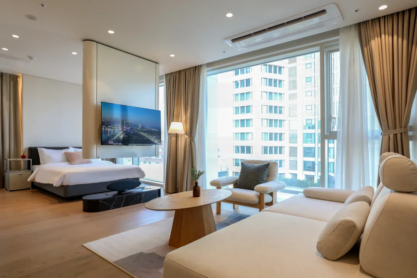Open-plan one-bedroom with a sofa, bed and city-view windows (Listing ID : 45208)