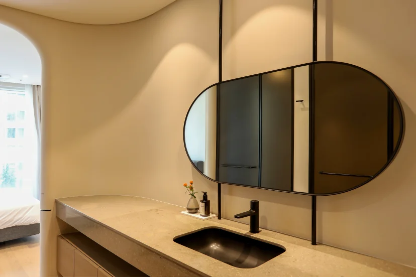 Bathroom vanity with a stone counter, black sink and an oval ceiling-hung mirror (Listing ID : 45208)
