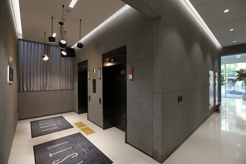 Ground-floor elevator lobby with dark stone walls and pendant lights (Listing ID : 45208)