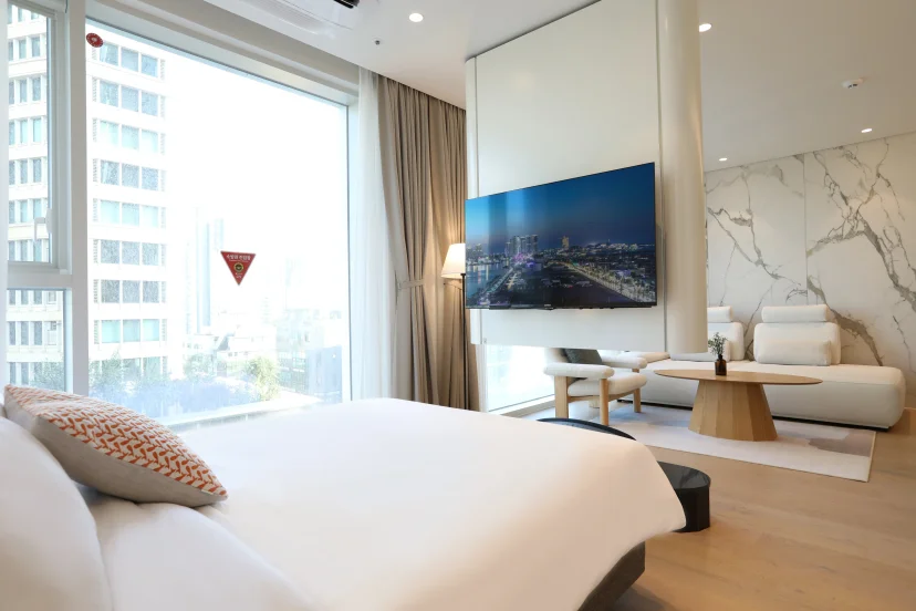 Bed in the foreground with a view through to the lounge and city windows (Listing ID : 45208)