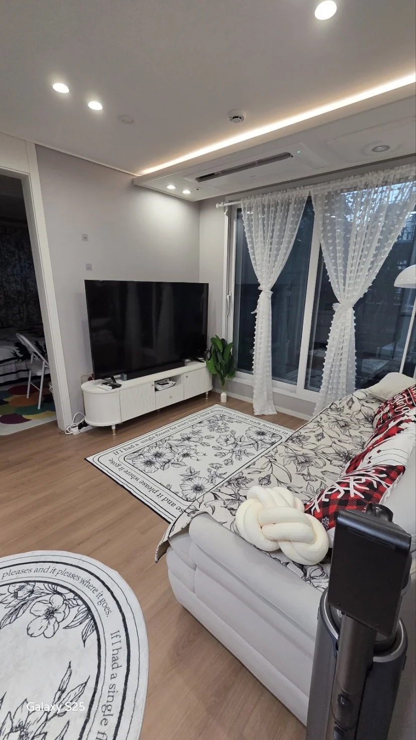 Cozy living room with white sofa, TV, and sheer curtains (Listing ID : 30308)