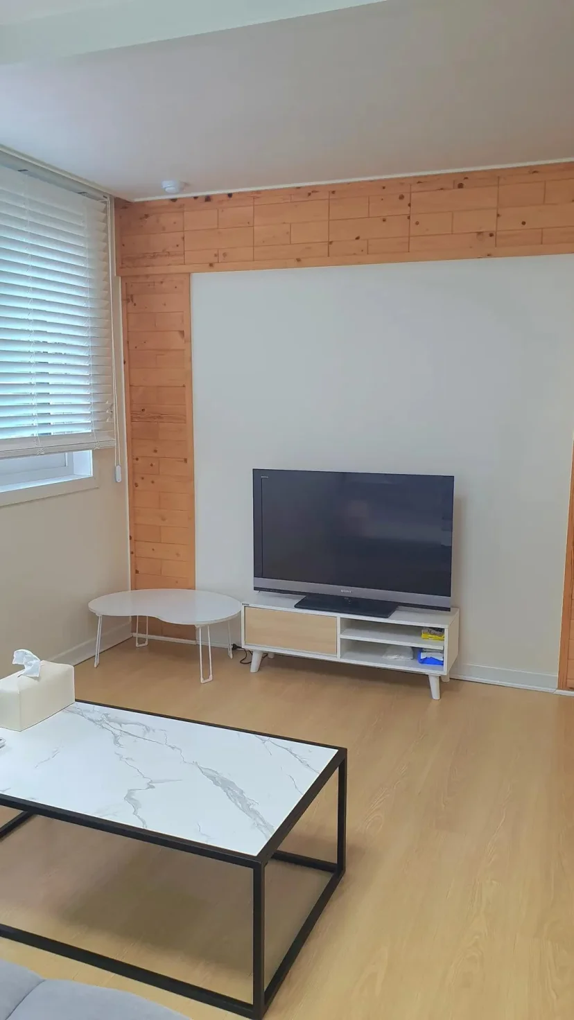 Living room with a TV and wood-panelled wall (Listing ID : 43566)