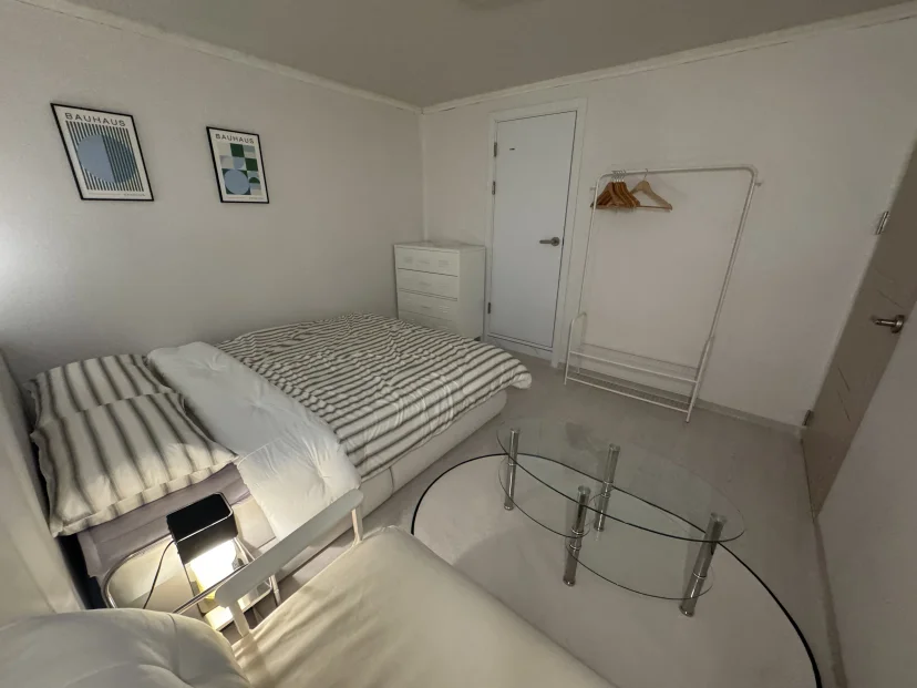 Bedroom with a double bed, posters and a clothing rack (Listing ID : 45817)