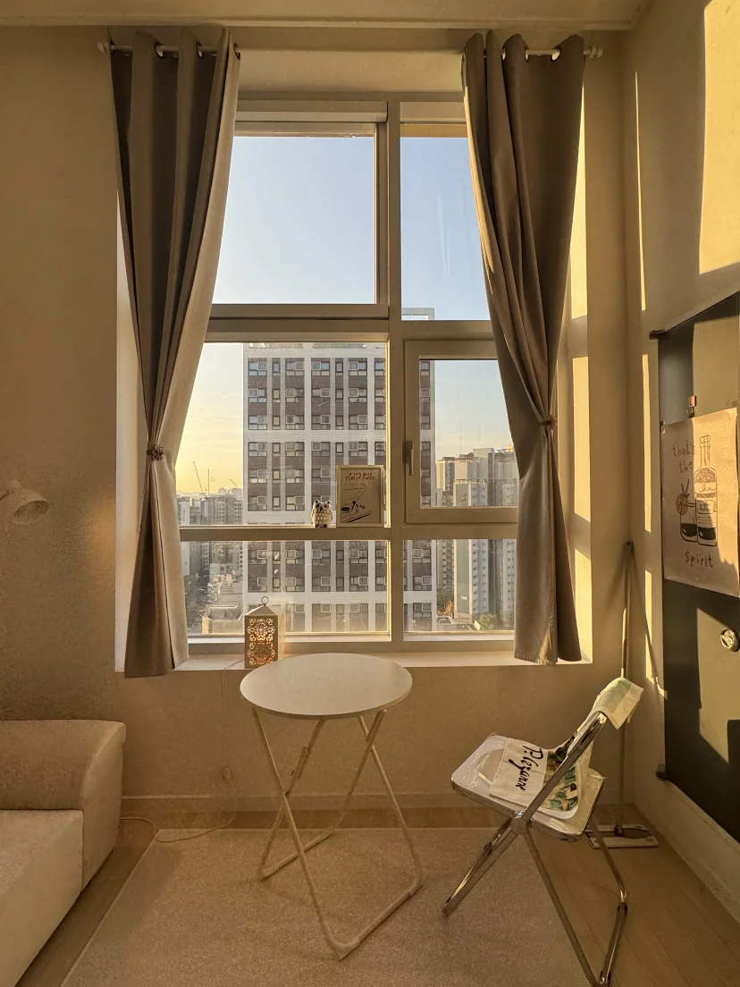 Loft studio window seat at sunset with city skyline view and white folding chair (Listing ID : 45885)