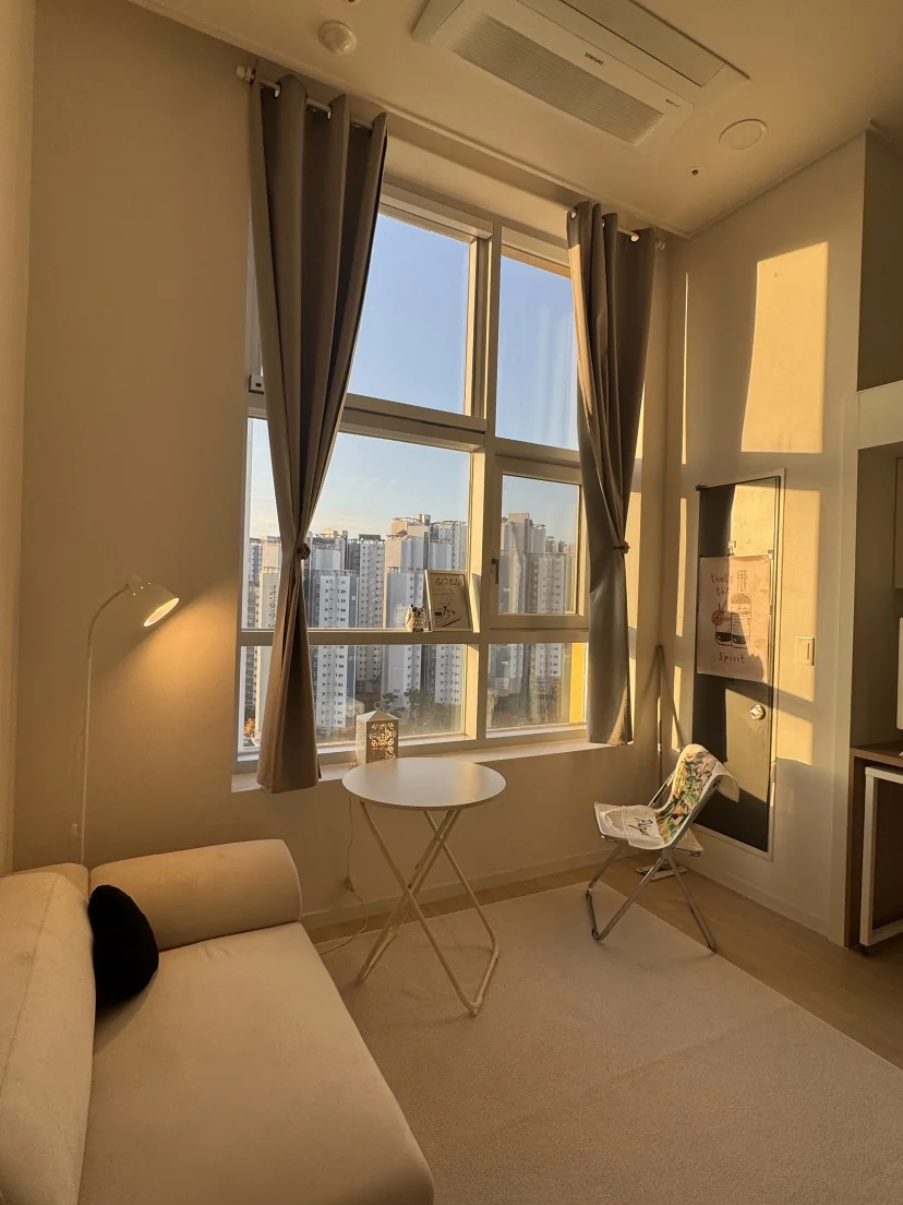 Loft living corner with floor lamp, beige sofa and high-rise sunset view (Listing ID : 45885)