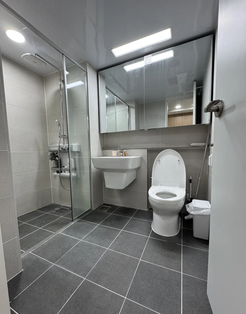 Modern gray-tile bathroom with walk-in glass shower and sink (Listing ID : 45885)