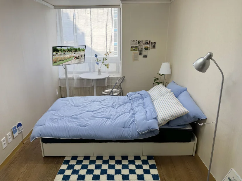Studio with blue bedding, floor lamp and window desk (Listing ID : 45640)