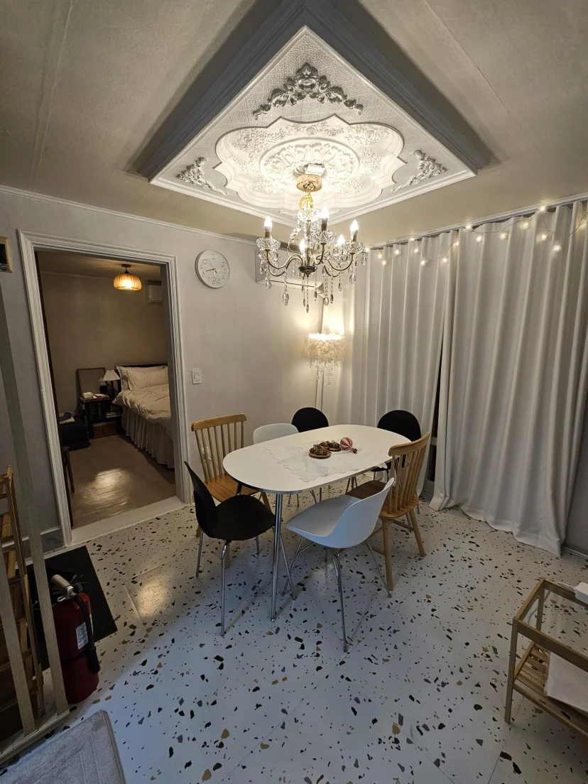 Dining area with round table, chairs and chandelier, bedroom visible through the doorway (Listing ID : 46711)