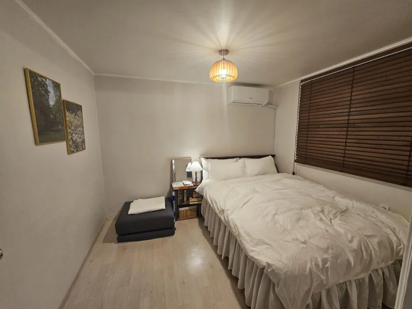 Bedroom with double bed, wood blinds, wall air conditioner and framed nature prints (Listing ID : 46711)