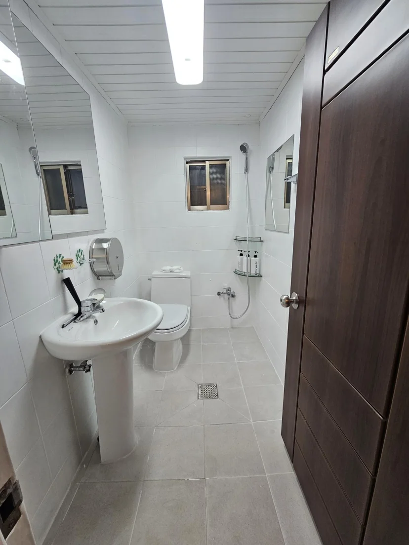 Bathroom with pedestal sink, toilet and handheld shower over a tiled floor (Listing ID : 46711)