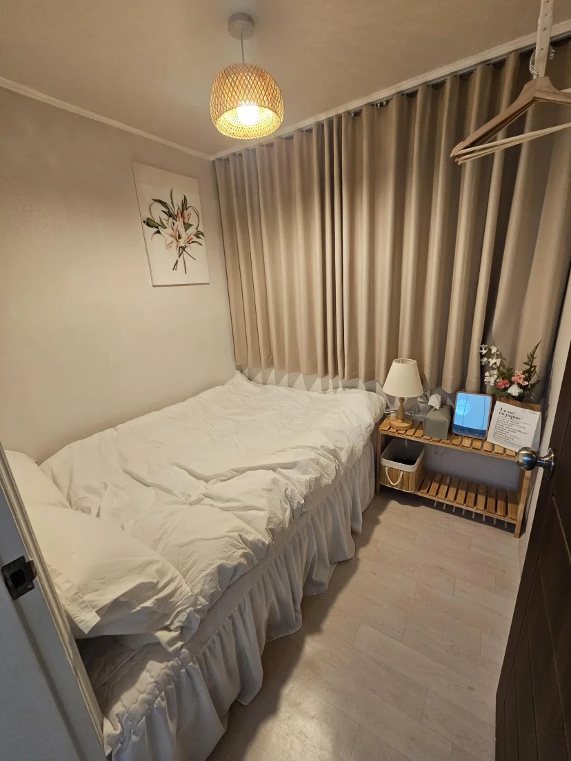 Bedroom with double bed, pendant light, floral print and a wooden bedside shelf (Listing ID : 46711)