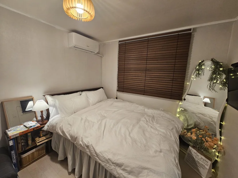 Bedroom with queen bed, wood blinds and an arched mirror with string lights (Listing ID : 46711)