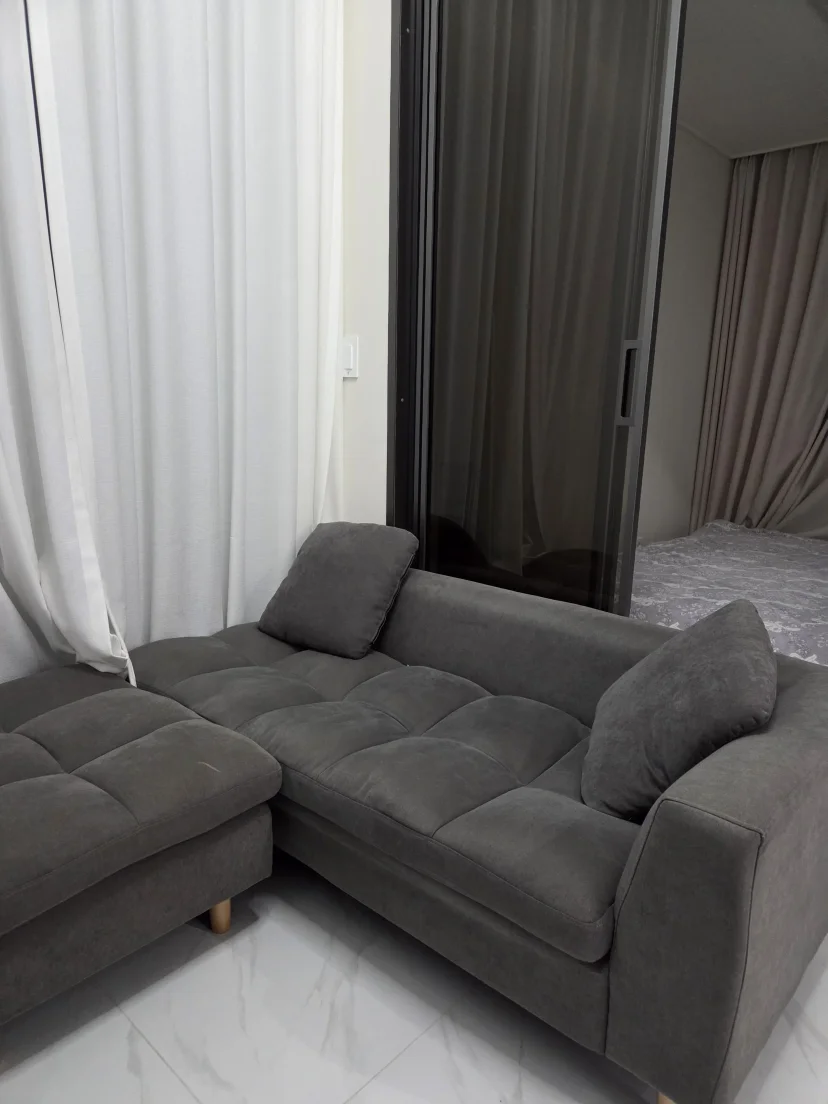 Grey sectional sofa and sheer curtains in the living area (Listing ID : 14692)