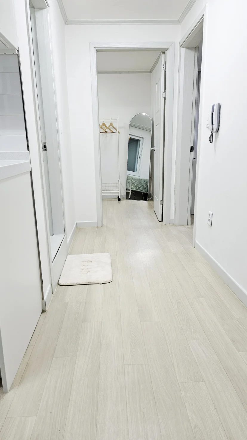 Bright white hallway with arched mirror leading to bedroom (Listing ID : 46906)