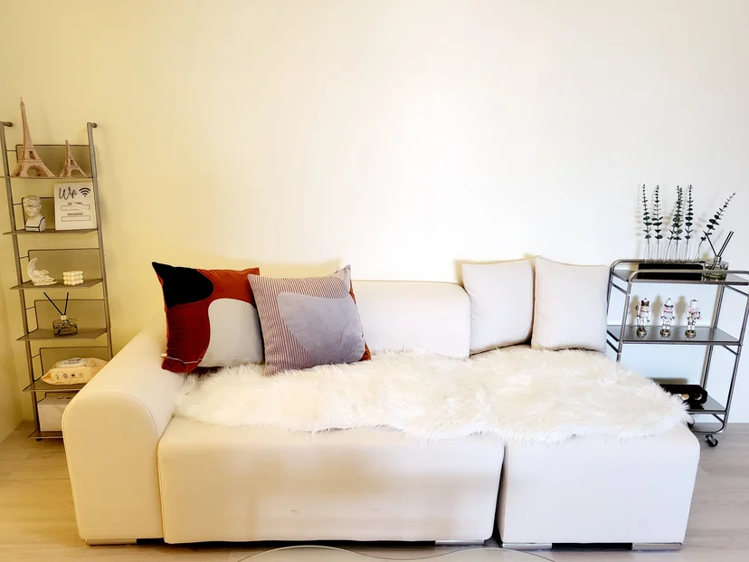 Cream sofa with cushions and a fur throw in a bright living room (Listing ID : 37856)