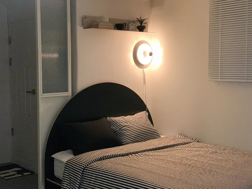 Bedroom with striped bedding and a dark headboard (Listing ID : 38554)